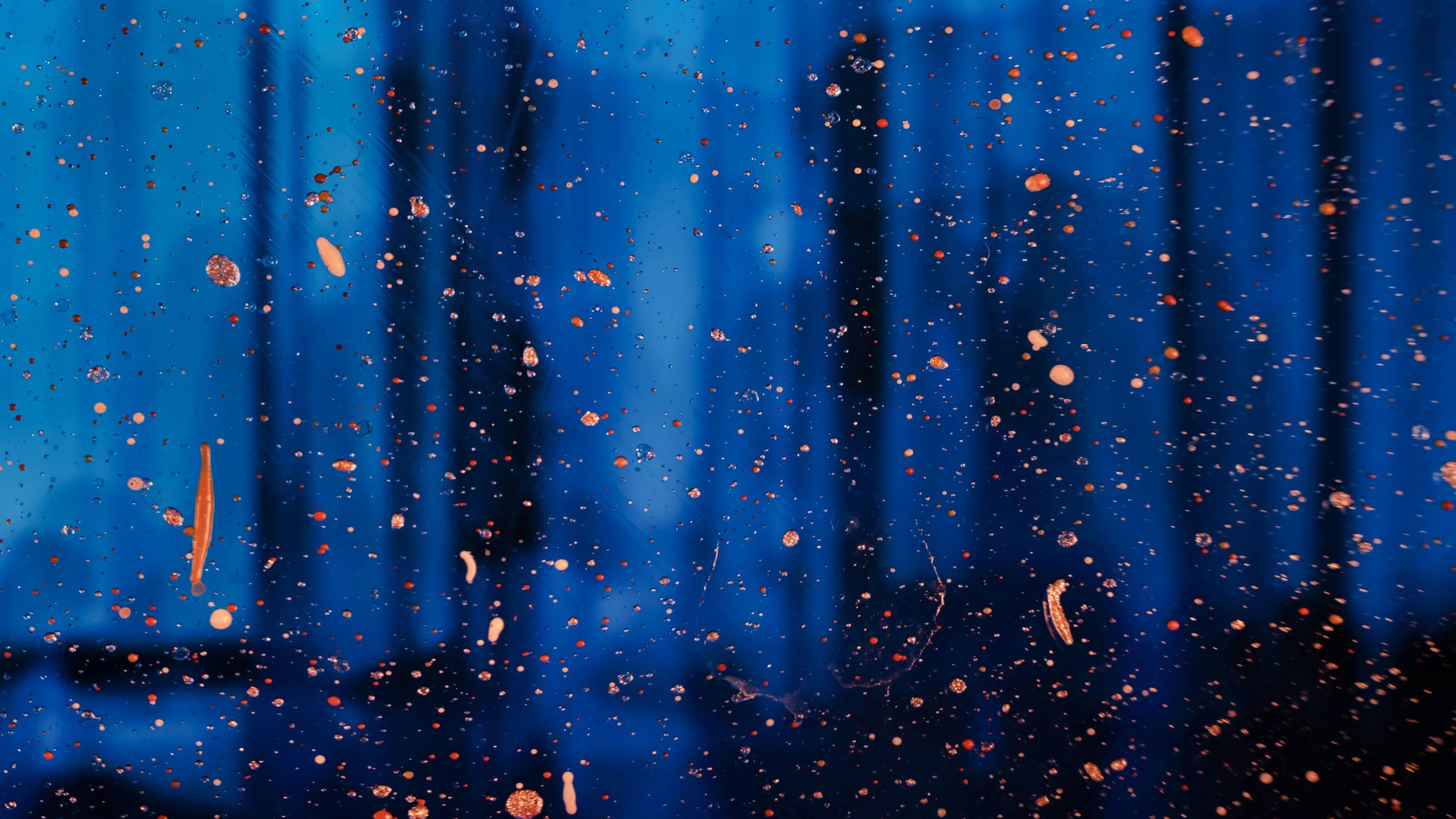 A bright blue and deep black scene suggesting nighttime in a forest, overlaid by copper splatters.